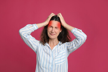 Woman suffering from headache on pink background