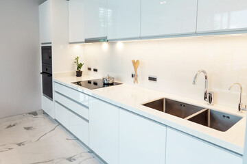 Modern Minimalist Kitchen with Sleek White Cabinets, Marble Floor, and Bright Natural Light Source