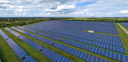 Aerial view of large sustainable electrical power plant with rows of solar photovoltaic panels for...