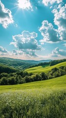 Obraz premium Serene green landscape under a bright blue sky with fluffy white clouds and sunbeams over rolling hills and meadow