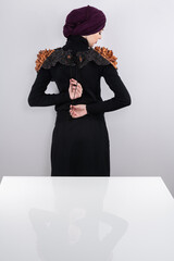 A stylish Muslim woman in a hijab presents her innovative handmade fashion accessory crafted from...
