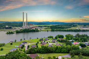 Rural homes close to coal run power station in Kingston, Tennessee. Air pollution from major coal-fired power plant producing electricity. Fossil fuel usage for energy production