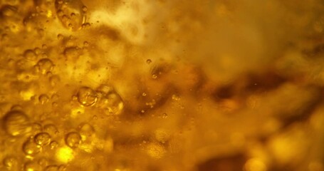 Extreme close-up view of beer bubbles floating to the top of the glass. Concept of beverage at the bar