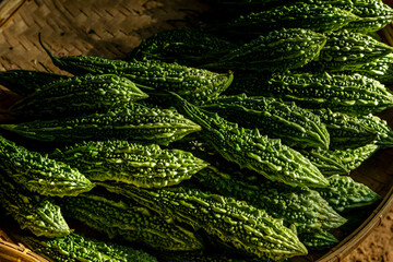 Momordica charantia often called bitter melon, bitter gourd or bitter squash in pile at the market closeup background