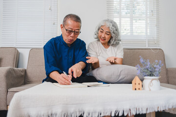 Elderly Couple Sitting on Sofa, Discussing and Writing in Notebook With Cozy and Relaxed Atmosphere.
