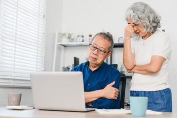 Obraz premium Elderly Couple Looking Concerned While Using Laptop at Home, Expressing Worry.