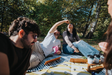 A group of friends having a relaxed picnic in the park, enjoying light snacks and each other's...