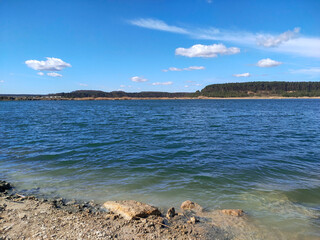 Scenic landscape with a lake, forest, and sky