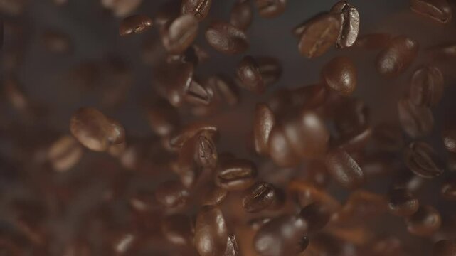 Coffee beans scattering on a grey smoky backdrop. Cold toned roastery and bean texture