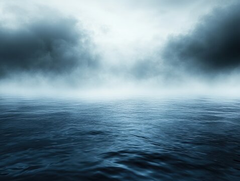 Serene expanse of dark blue ocean waters under a misty sky with dramatic clouds creating a moody and atmospheric seascape for stock photography