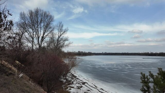 slow motion video winter landscape on frozen lake. cracked ice on river. Bird watching in the wild. Slow motion video in 4k. Hand held video of lake shore frost winter cold wether