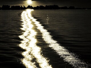 Golden shimmering wakes trails after boat gliding on tranquil river
