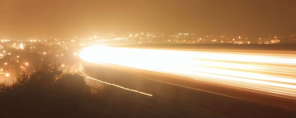 Long exposure photograph shows vehicle light trails illuminating a night landscape