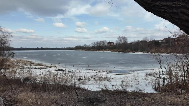 slow motion video winter landscape on frozen lake. cracked ice on river. Bird watching in the wild. Slow motion video in 4k. Hand held video of lake shore frost winter cold wether