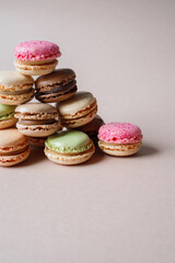 Pyramid made of multicolored macarons desserts on beige background