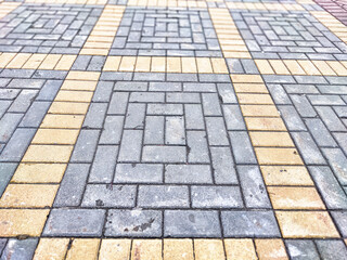 Unique patterned pavement tiles create a visually appealing pathway design in an urban setting
