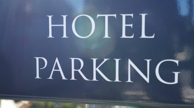 Hotel parking sign board in sunlight, directional sign for arriving transport at the hotel entrance, additional information for drivers