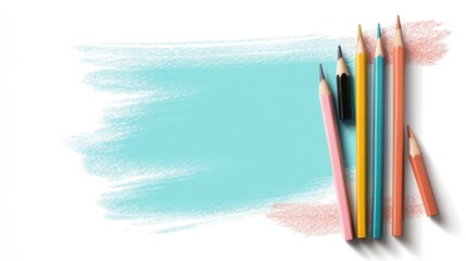 Colorful pencils arranged near a light blue paint stroke on white background.