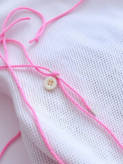Pink thread with needle and buttons