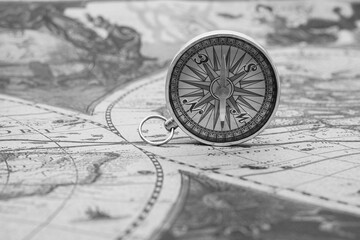 Classic round compass on background of old vintage map of world