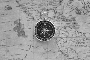 Classic round compass on background of old vintage map of world