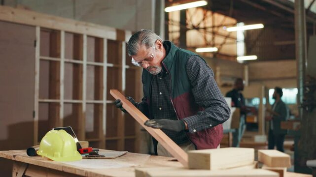 Carpentry, woodwork and man in workshop for sanding wood for furniture, manufacturing or lumber production. Construction, factory and carpenter with tools for planks, timber and board for restoration