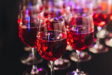 Alcohol setting on catering banquet table, row line of orange red coloured aperitif alcohol cocktails on party, negroni, spritz and others on bar counter, selection of liquor beverages on event