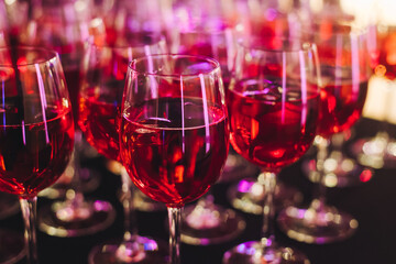Alcohol setting on catering banquet table, row line of orange red coloured aperitif alcohol cocktails on party, negroni, spritz and others on bar counter, selection of liquor beverages on event