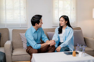 Fototapeta premium Young couple embracing, displaying affection while standing close together in cozy home interior