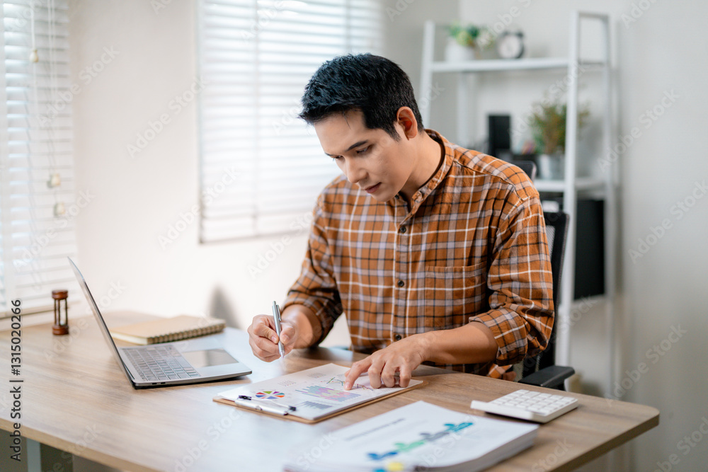 Poster young entrepreneur analyzing financial data using laptop and documents working from home office
