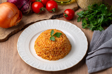 Traditional turkish bulgur pilaf with tomato sause in plate (Turkish name; meyhane pilavi)