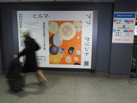 TOKYO, JAPAN - March 7, 2025: Person passing a billboard in a train station advertising a Hilma af Klint exhibition at Tokyo's Museum of Modern Art.