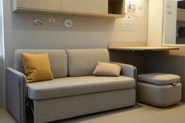 A modern space with a convertible loveseat, a wall-mounted folding desk, and a small storage ottoman