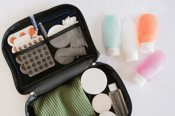 Cosmetic travel kit on the bed. colorful cosmetic bottles