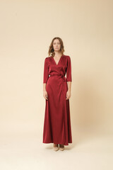 Serie of studio photos of female model in luxury minimalistic silk satin red maxi wrap dress.	