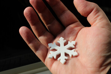 Cold weather forecast for the elderly people. White Artificial Snowflake on a Palm of Old Man Closeup View
