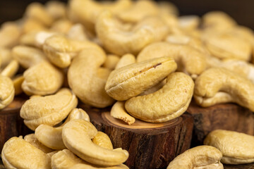 large cashew nuts are scattered on a larch board