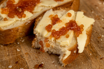 a soft loaf of wheat flour with butter and red salmon caviar