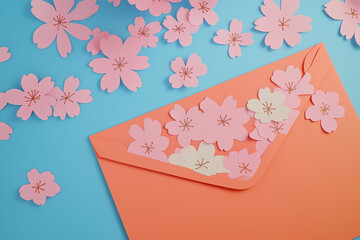 Pink envelope with orange paper and paper cherry blossoms on a blue background with copy space. Spring greeting card for Easter, Mother's Day, Women's Day celebrations.