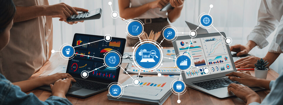 Panorama shot analyst team utilizing BI Fintech to analyze financial report with laptop. Businesspeople analyzing BI power dashboard displayed on laptop screen for business insight. Scrutinize Amity - Powered by Adobe