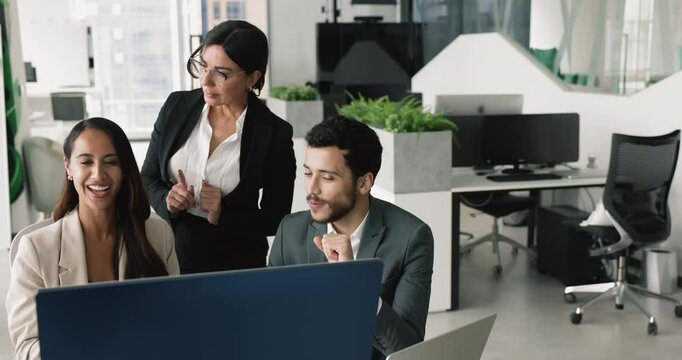 Positive diverse business team watching content on monitor in office, discussing traffic statistics, online startup growth, e-commerce website, Internet project presentation, pointing computer screen
