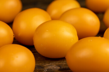 a large number of ripe orange tomatoes that are on the table