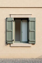 Fototapeta premium A partially opened sage green window shutter on a light beige building facade