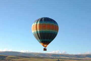 Obraz premium vibrant hot air balloon floats gracefully against clear blue sky evoking sense of adventure and freedom with passengers