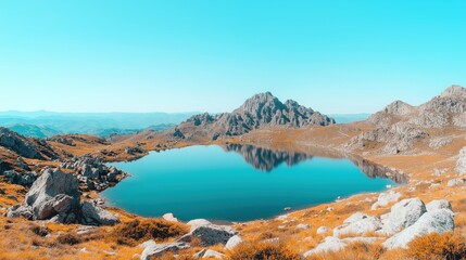Tranquil mountain lake reflecting stunning peaks under clear blue sky in vibrant autumn landscape