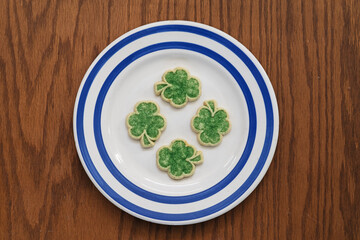 Green Shamrock Sugar Cookies On White Plate With Blue Stripes