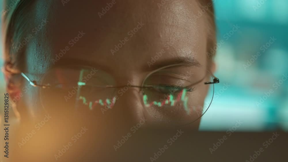 Poster trader wearing glasses is working on laptop computer. screen with stock market charts and bitcoin bt