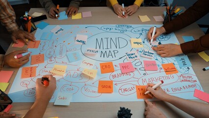 A group of diverse individuals engages in a dynamic brainstorming session, using colorful sticky...