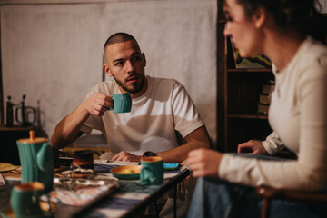 Two individuals engaged in a thoughtful conversation while enjoying cups of coffee. The atmosphere...