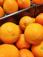 Oranges piles in boxes in grocery store. Fruit food background. Healthy diet. Organic product. Farmers market produce.